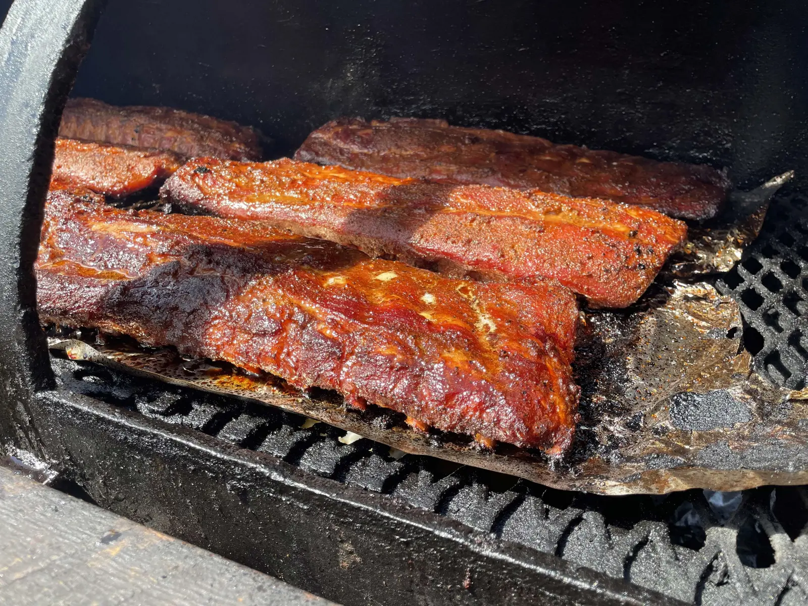 Racks of ribs cooking on the smoker grate